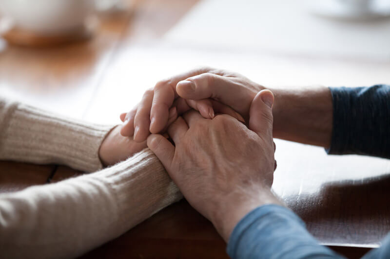 Hands clasped together in comfort