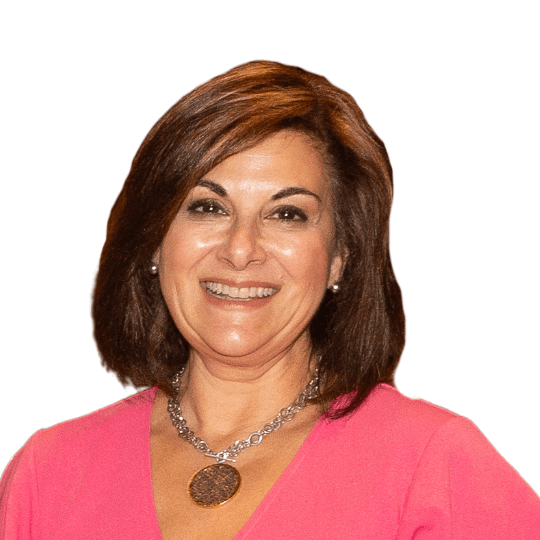 Smiling woman in pink blouse with short brown hair and a necklace on a white background.