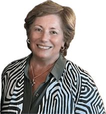 Senior woman smiling in patterned blouse, wearing necklace, isolated on white background. Business professional headshot photo.